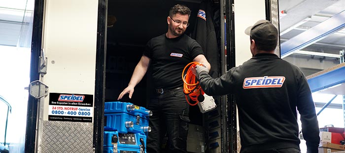 SPEIDEL Mitarbeiter laden Geräte zur technischen Trocknung von Wasserschaden und Brandschaden in Fahrzeug