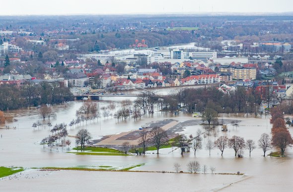 Hochwasser durch Starkregen an der Weser. Überflutete Felder und Häuser. Hilfe bei Wasserschaden durch Regen